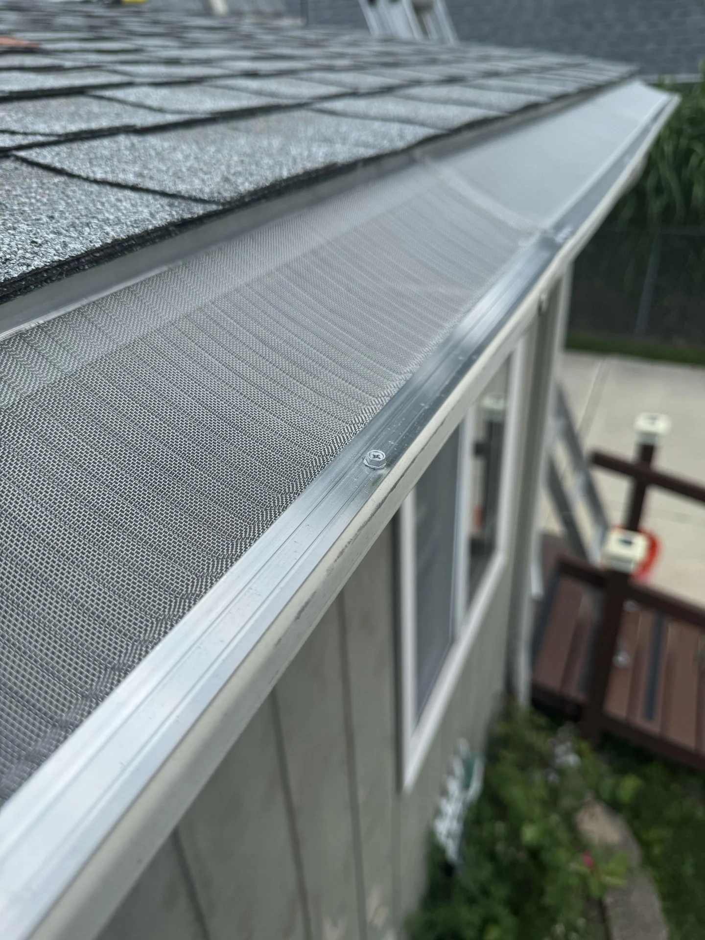 Technician installing micro-mesh gutter guard on a home